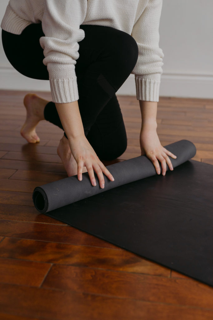 yoga teacher rolling up her mat