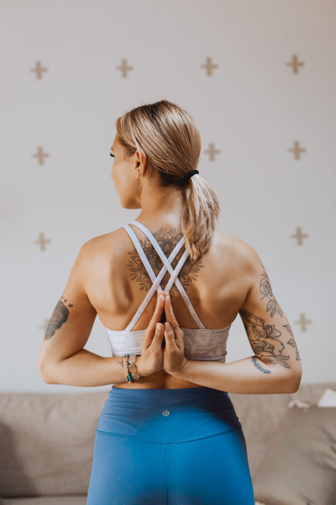 yoga teacher in reverse prayer behind her back