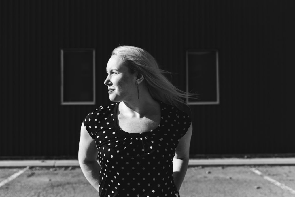 girl looking into the sun in polkadot shirt in black and white