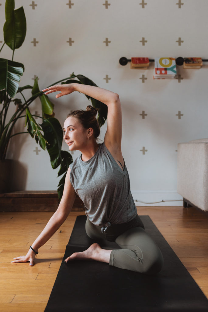 yoga teacher in pigeon pose in living room