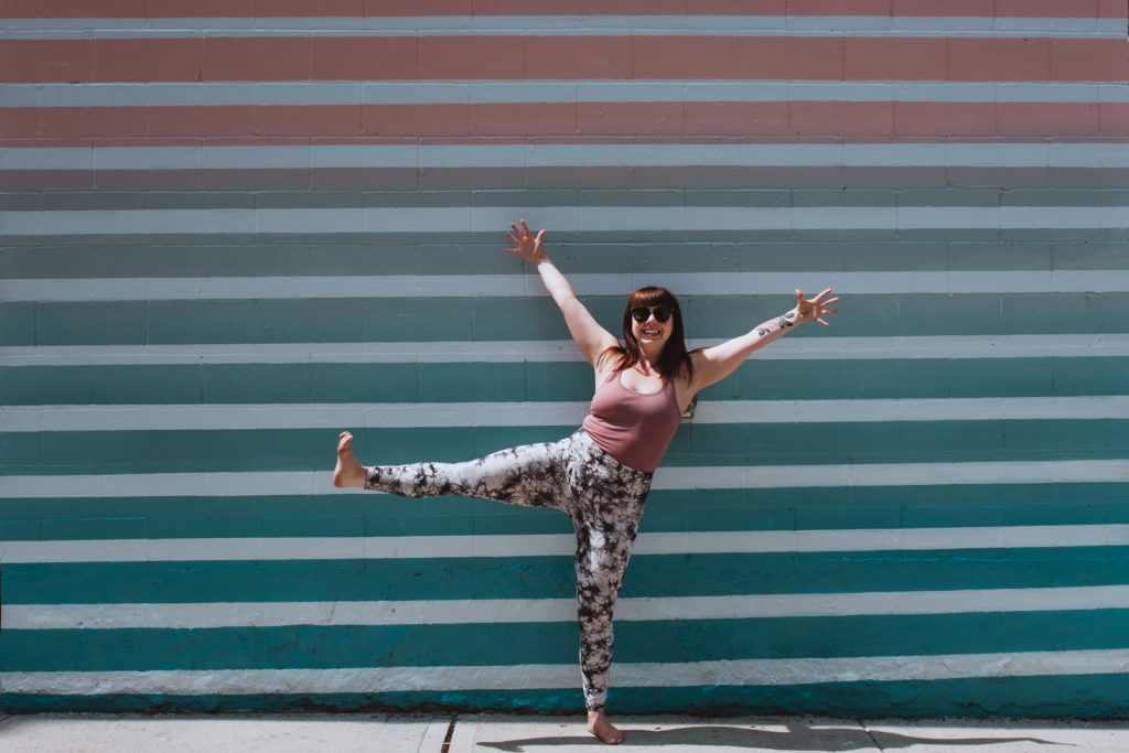 yoga teacher in star pose against pastel wall