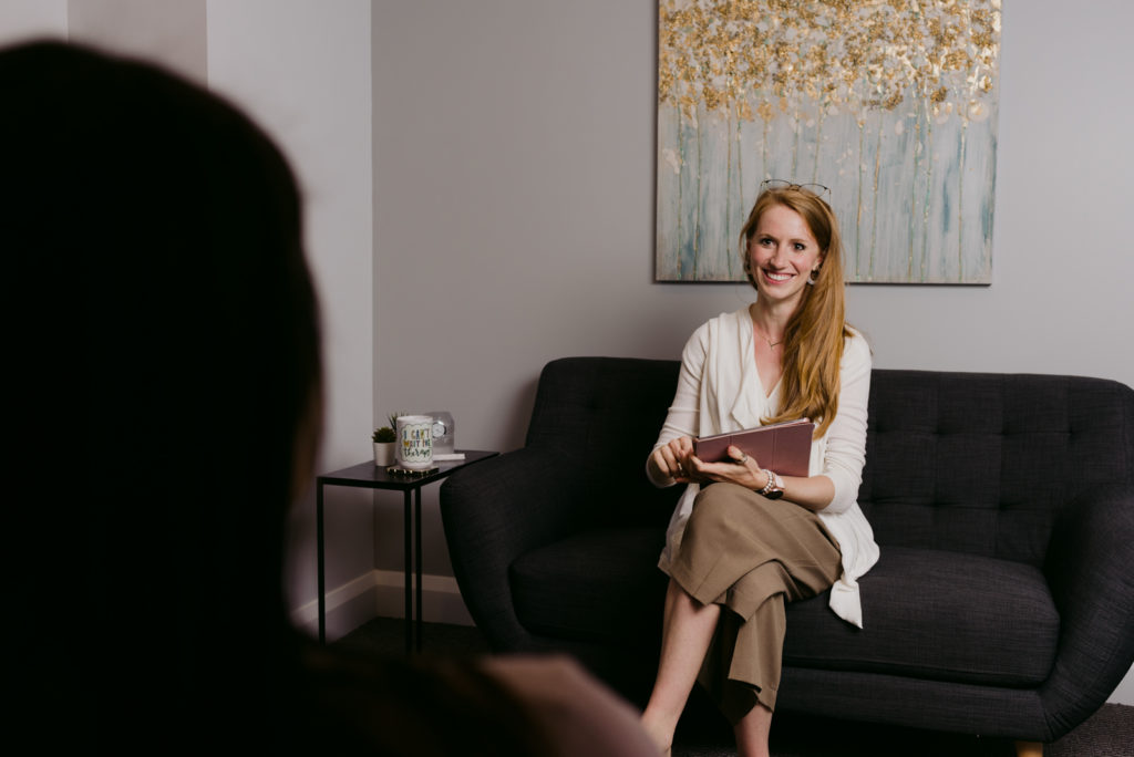 Therapist Tesia Bryski smiling at her client sitting on a couch