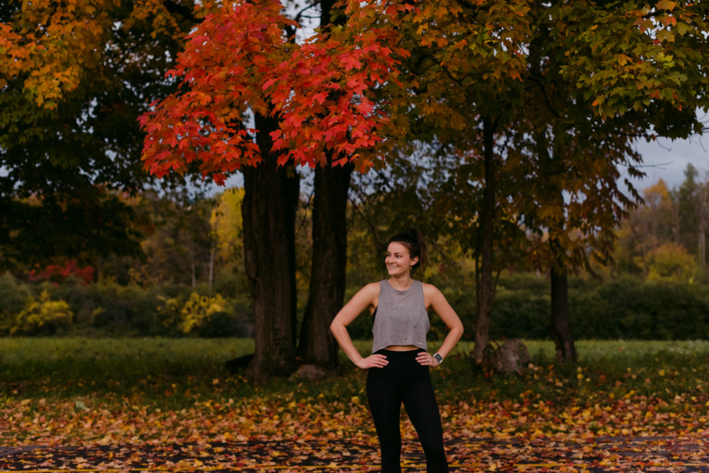 physiotherapist in lululemon apparel standing in a field with fall leaves