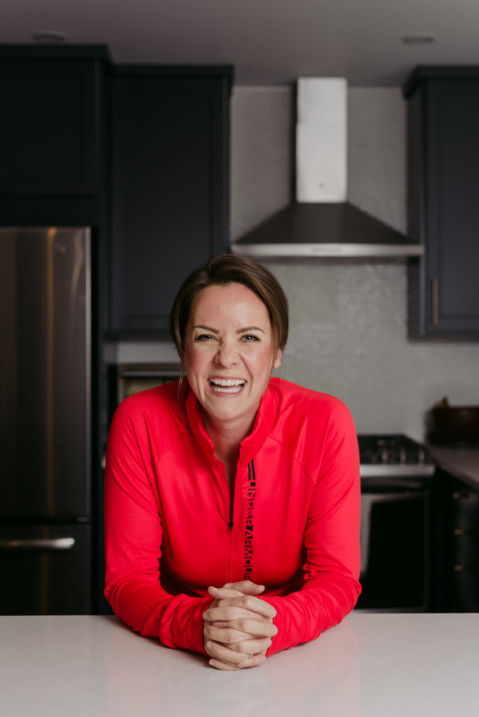 woman standing at the kitchen counter smiling at the camera