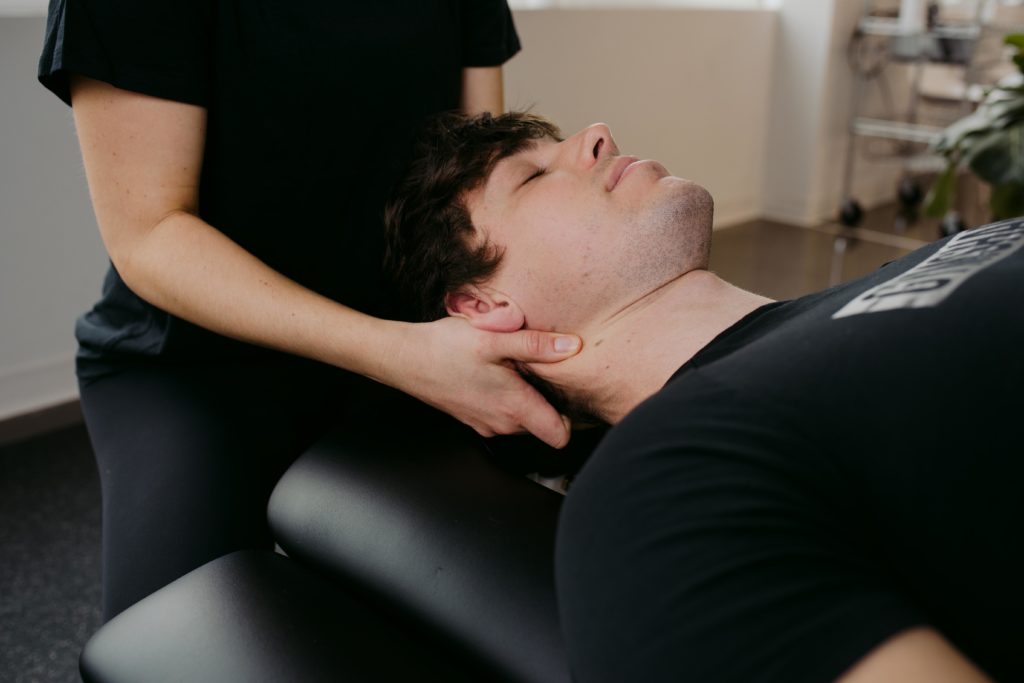 physiotherapist giving neck adjustment to client