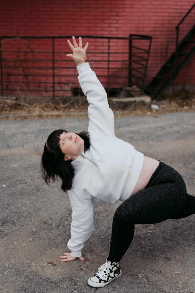 ottawa yoga teacher in easy twist in a gravel alley