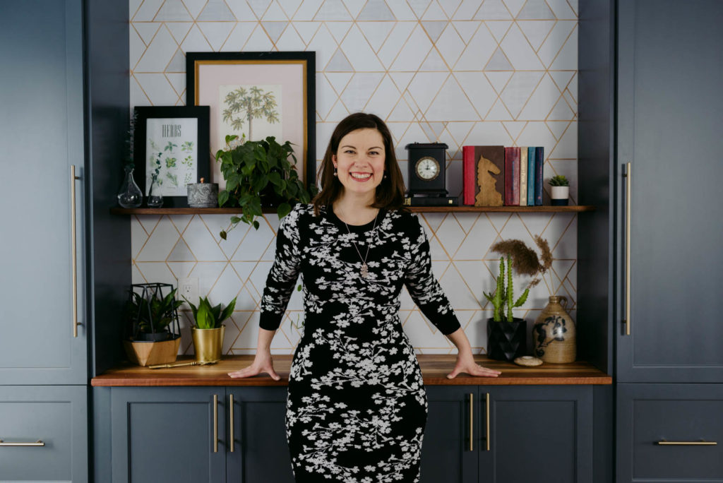 female entrepreneur in front of shelves with books and wallpaper details