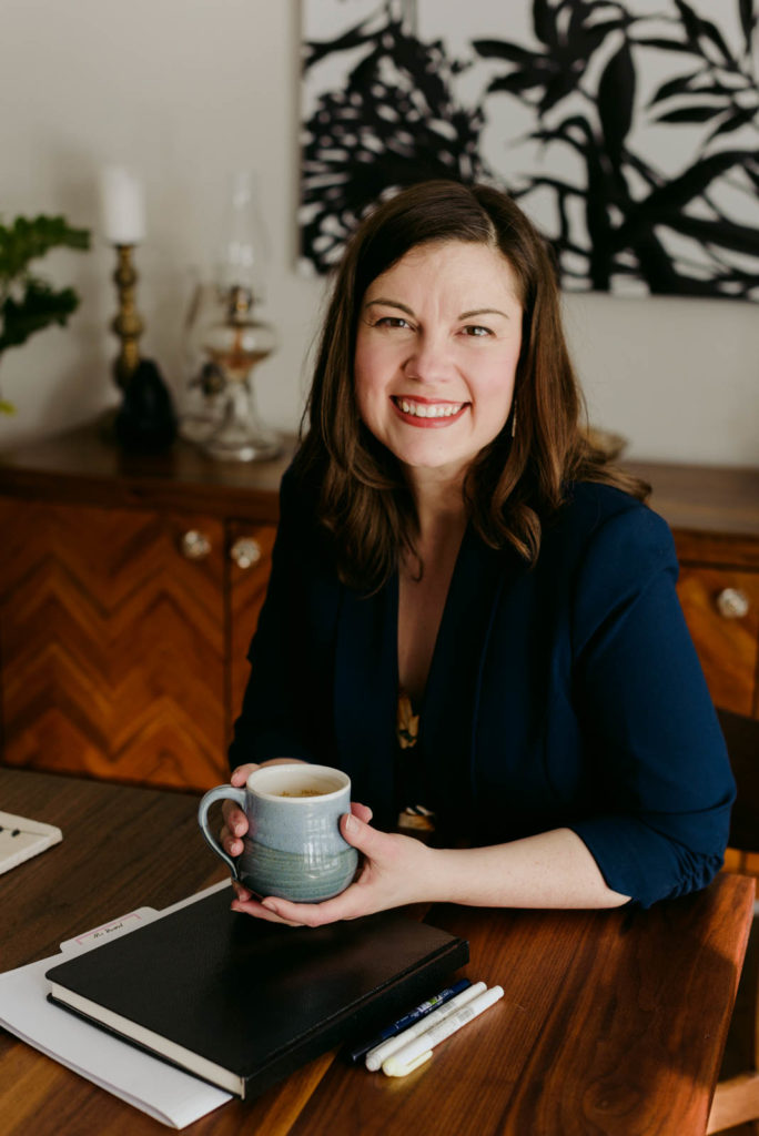 female entrepreneur with coffee and notebook at a dining room table