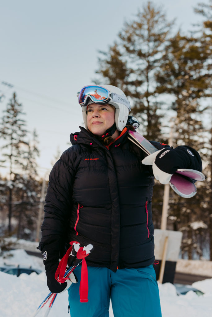 Real estate agent Daria Kark with her downhill skis over her shoulder