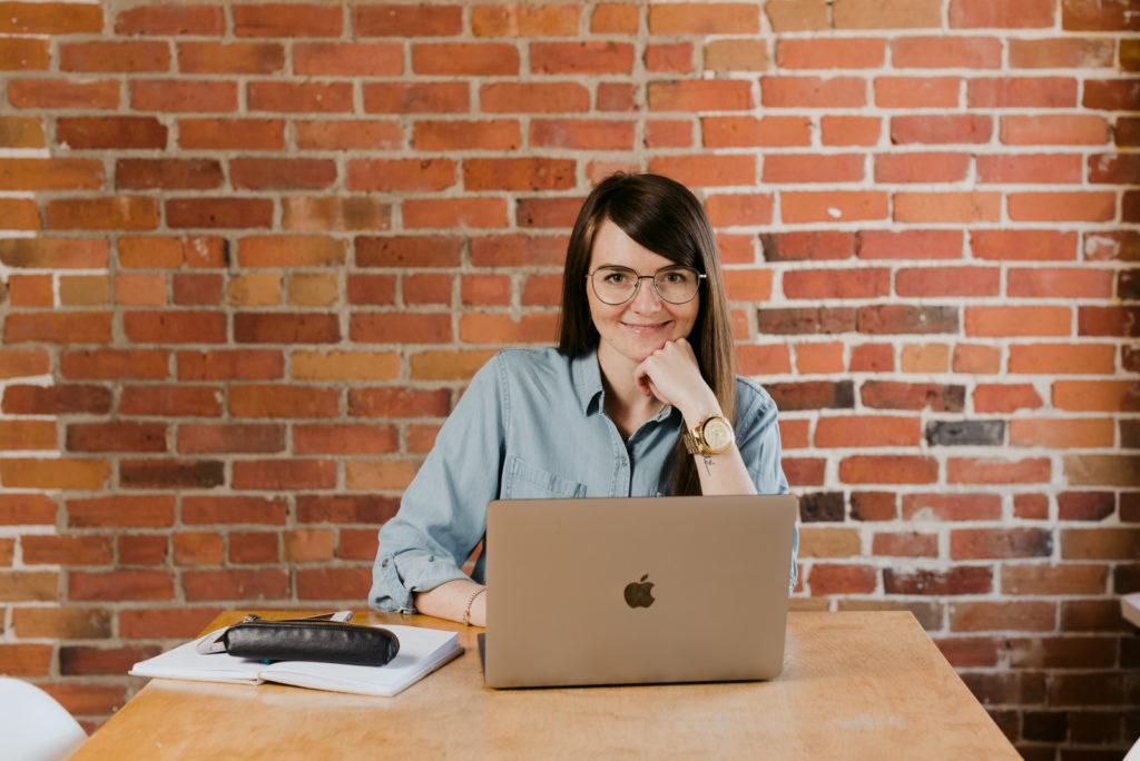 digital marketer wearing glasses sitting at a table with laptop