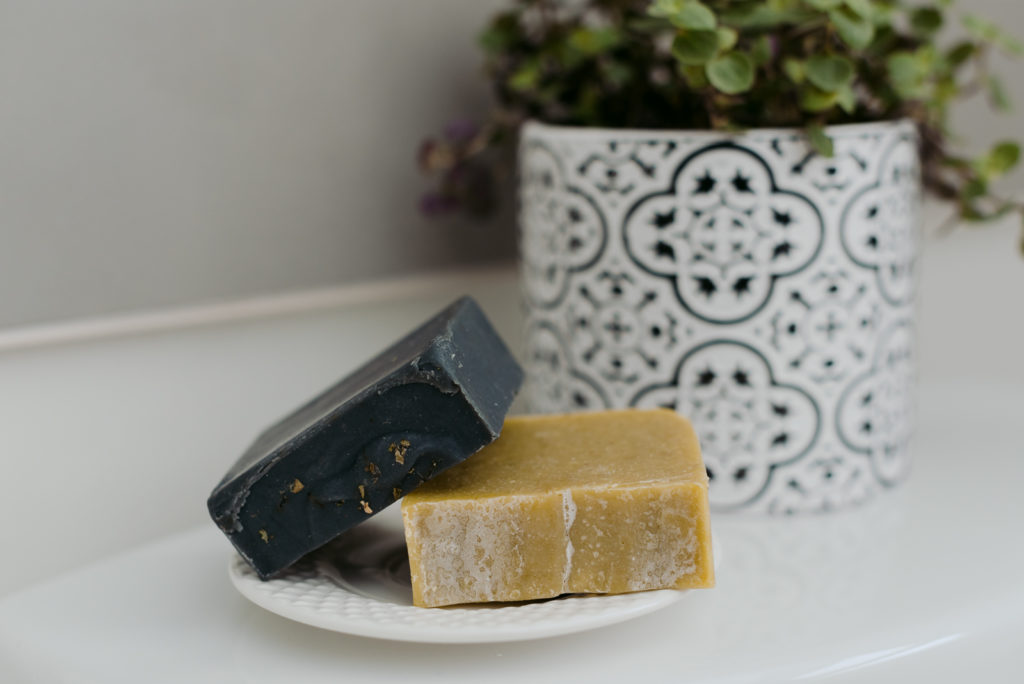 charcoal infused soap and tea tree oil soap on soap dish in the bathroom