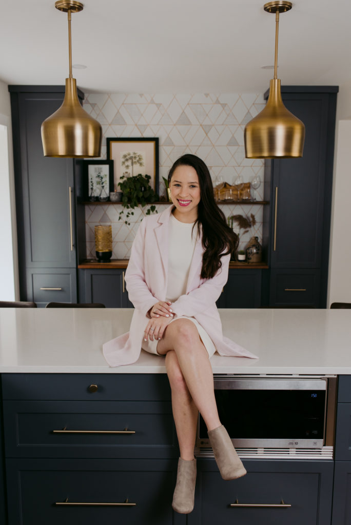 female real estate agent sitting cross legged on the kitchen counter