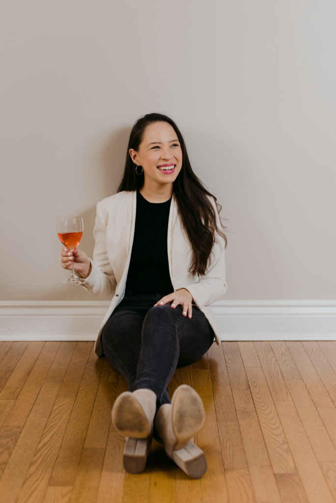 Real estate agent sitting on the floor drinking rose and smiling