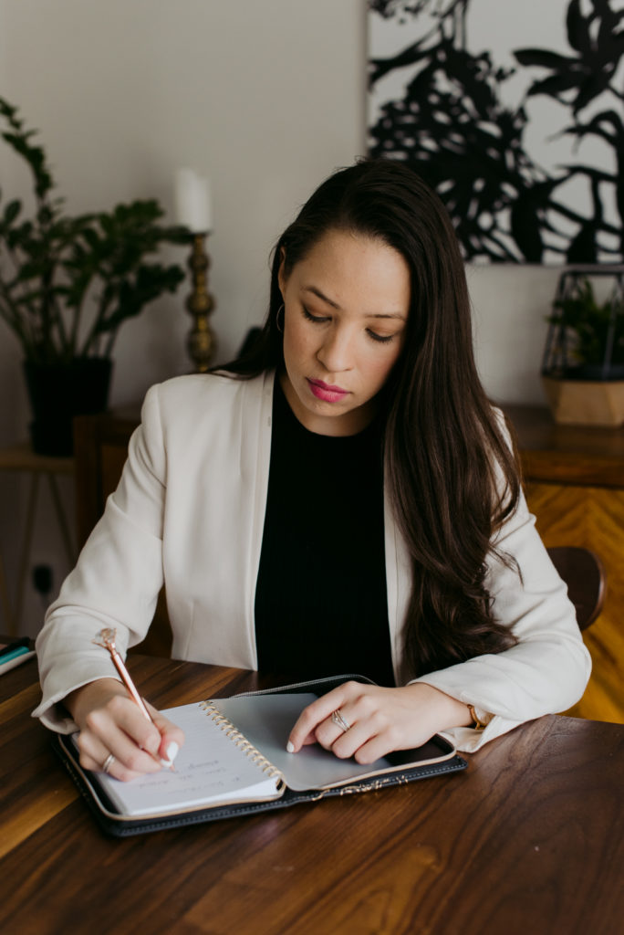 real estate agent taking notes in a notebook at a wooden table