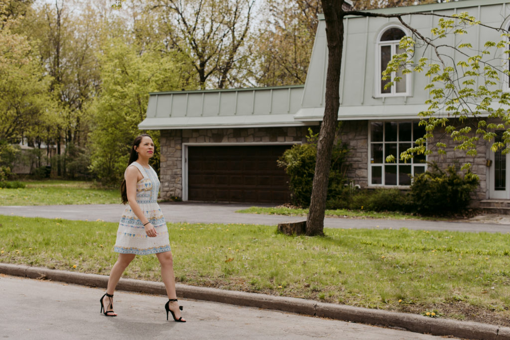 real estate agent walking down the street in front of house