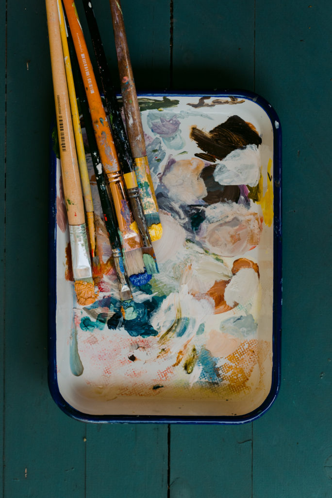 tray of paint brushes with paint