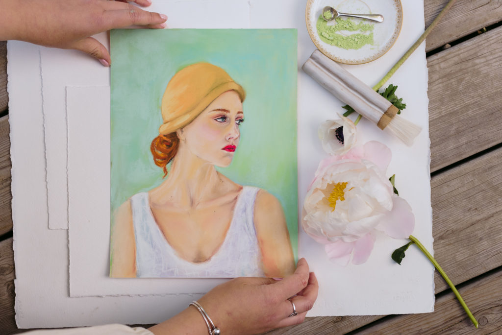 woman adjusting pastel portrait of a woman with florals and pastels with spoon