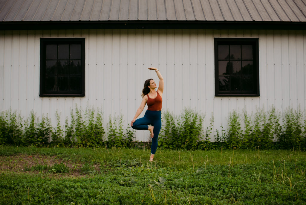 ottawa yoga teacher in tree pose in front of old white barn