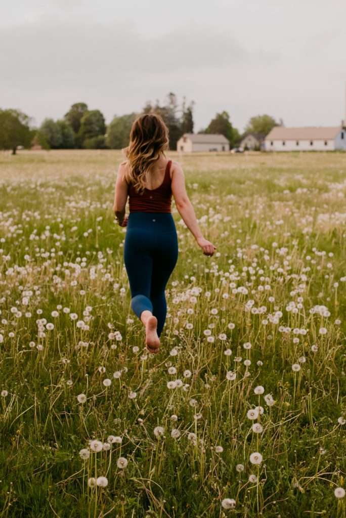 ottawa yoga teacher running in a field of dandelions