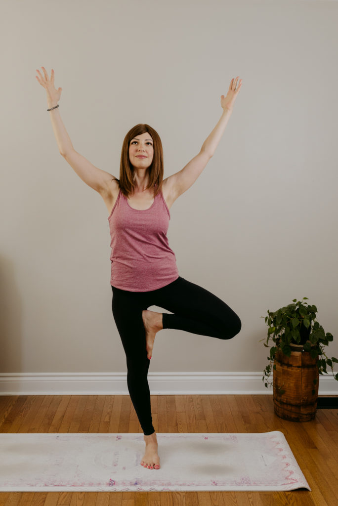 lifestyle photos of doctor in tree pose on yoga mat