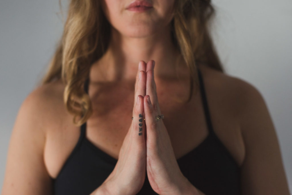 yoga teacher with hands together in front of heart