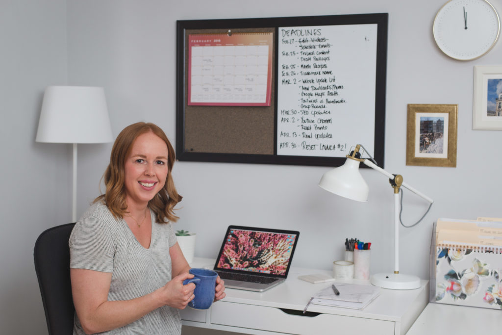 Stephanie Kay sitting at her desk at home drinking coffee