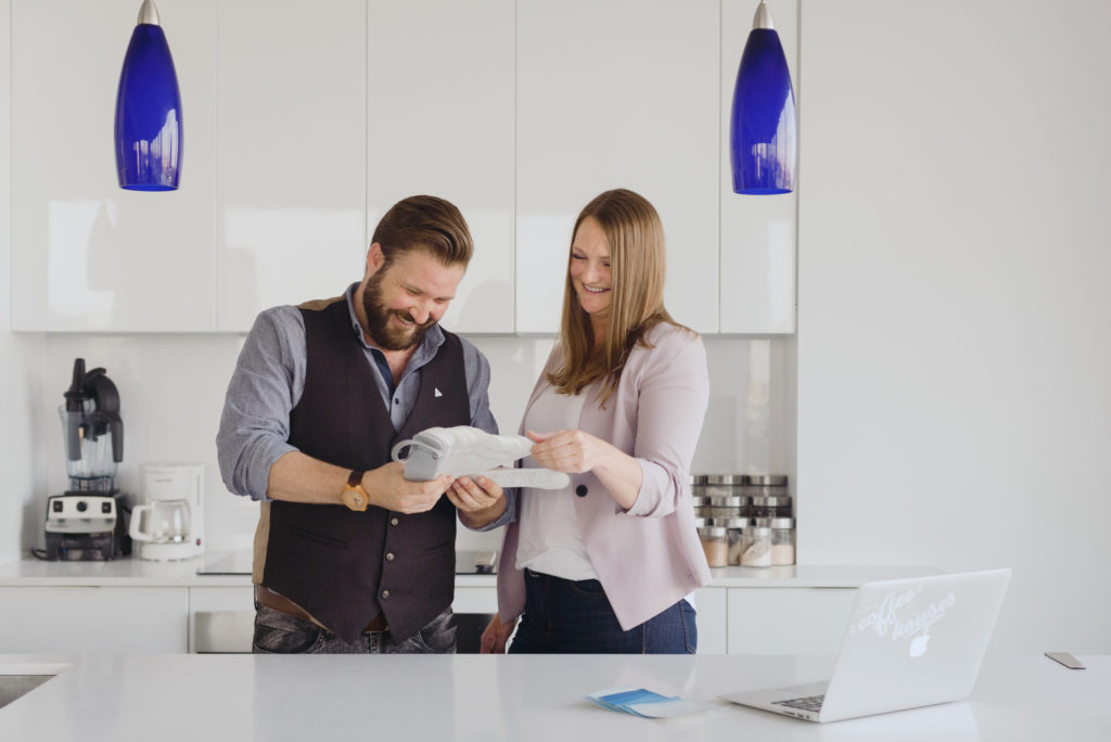 real estate agent and decorator looking at paint colours in white kitchen
