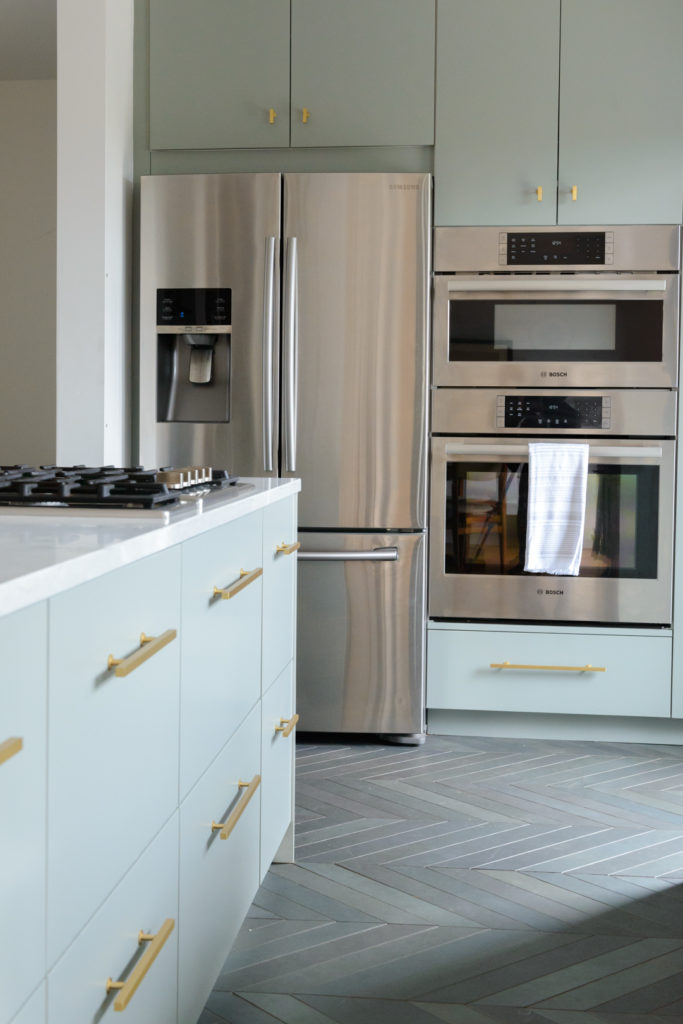 sage green kitchen cabinets and stainless steel appliances