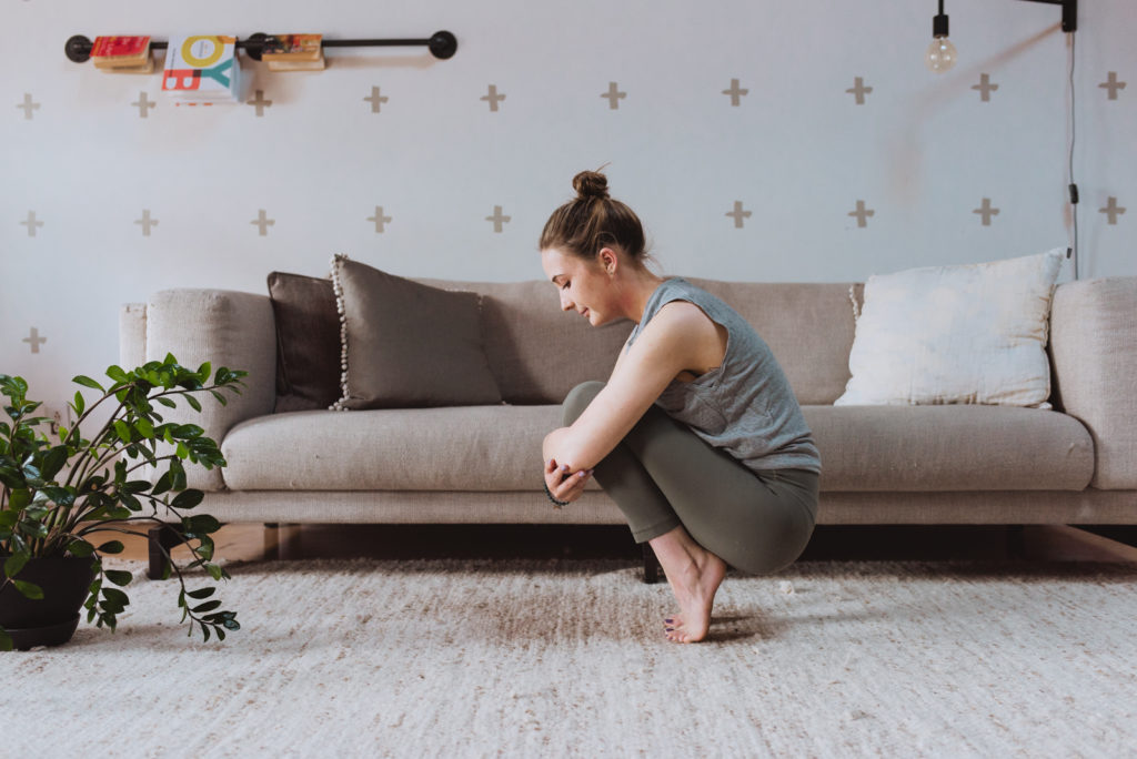 yoga teacher in toe stand in living room