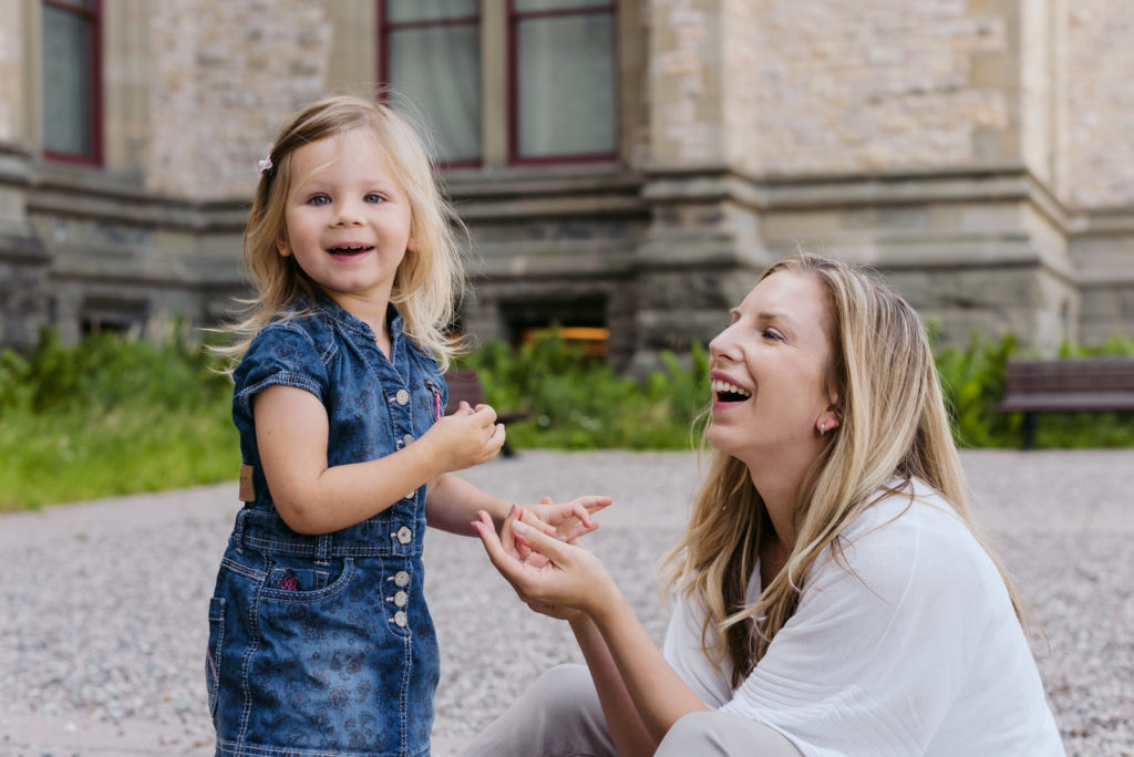 clinical psychologist laughing with her daughter outside stone building