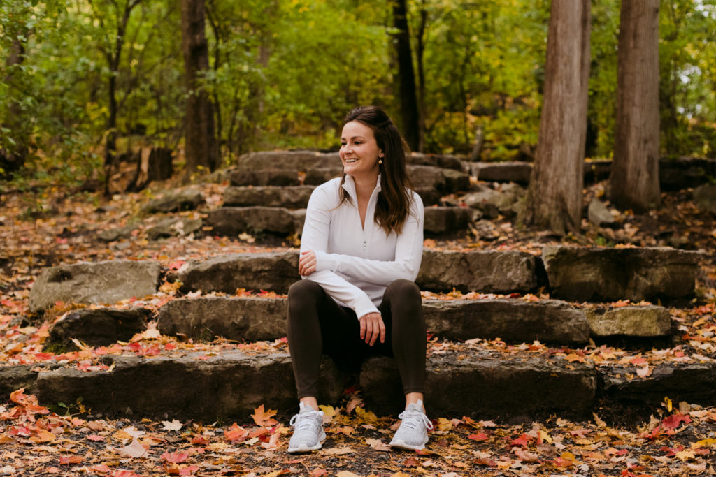 physiotherapist in lululemon apparel outside sitting on rock steps in the woods