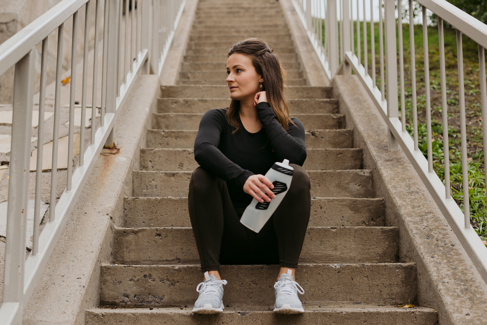 physiotherapist holding water bottle sitting on a staircase