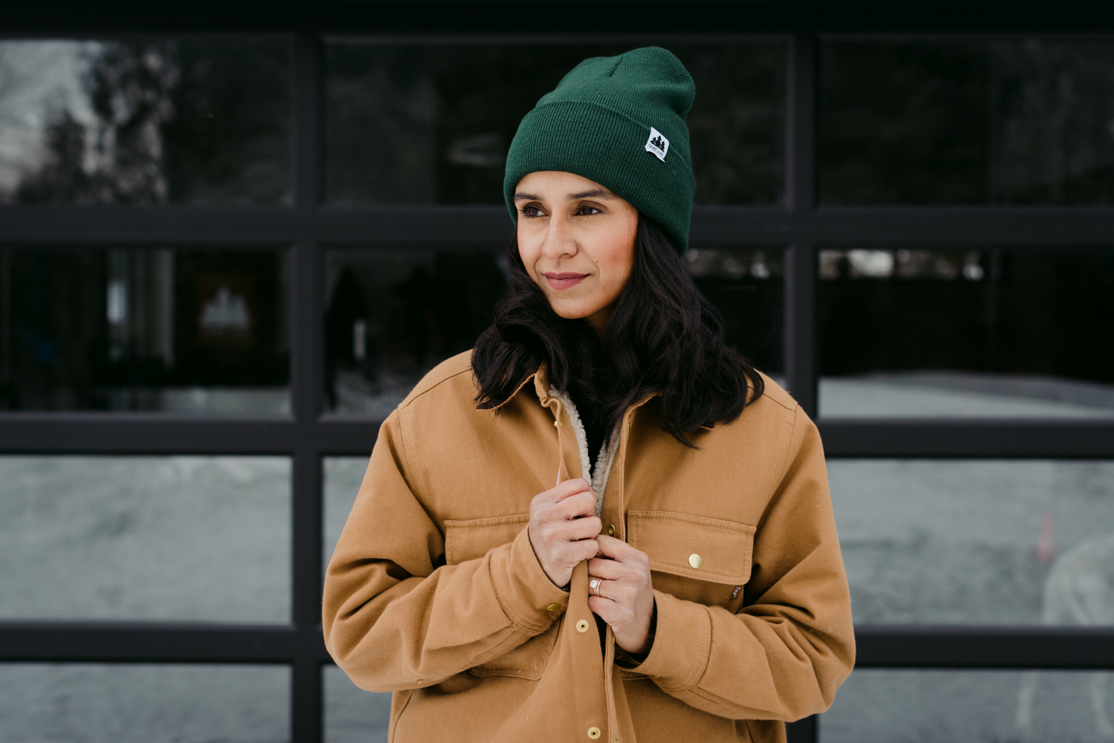 girl wearing a forest green toque cozying up outside