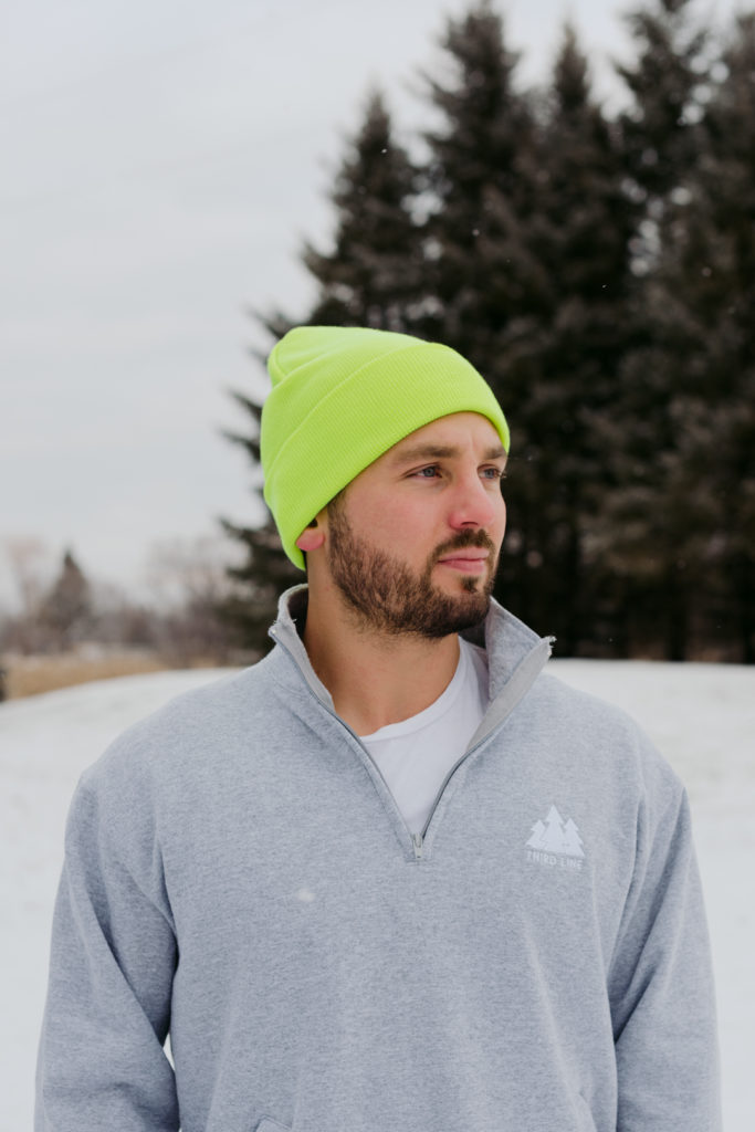 man wearing a green neon toque in the snow