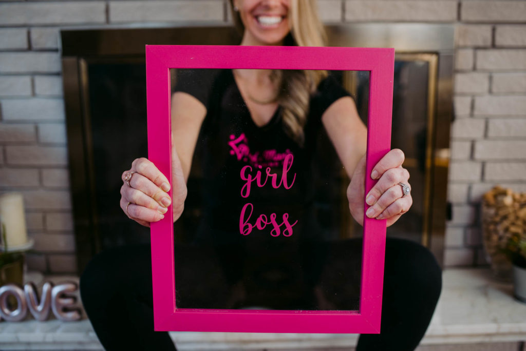 house cleaner holding up a frame that says girl boss