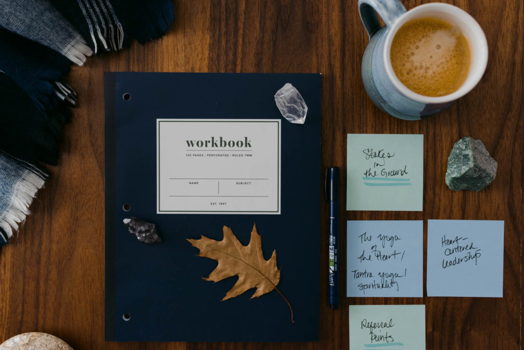flat lay of workbook, post-it notes and coffee