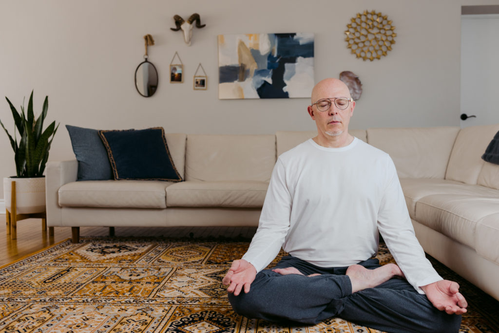 yoga teacher sitting in the living room in seated meditation