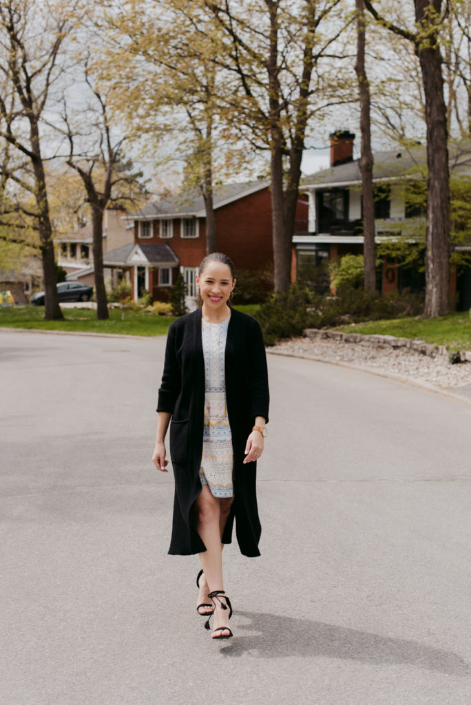 real estate agent walking down residential street smiling at the camera
